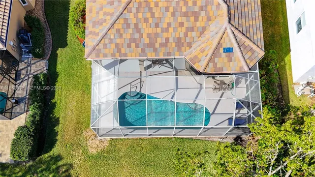an aerial view of residential houses with outdoor space and trees all around
