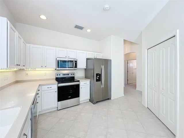 a kitchen with granite countertop white cabinets and white appliances