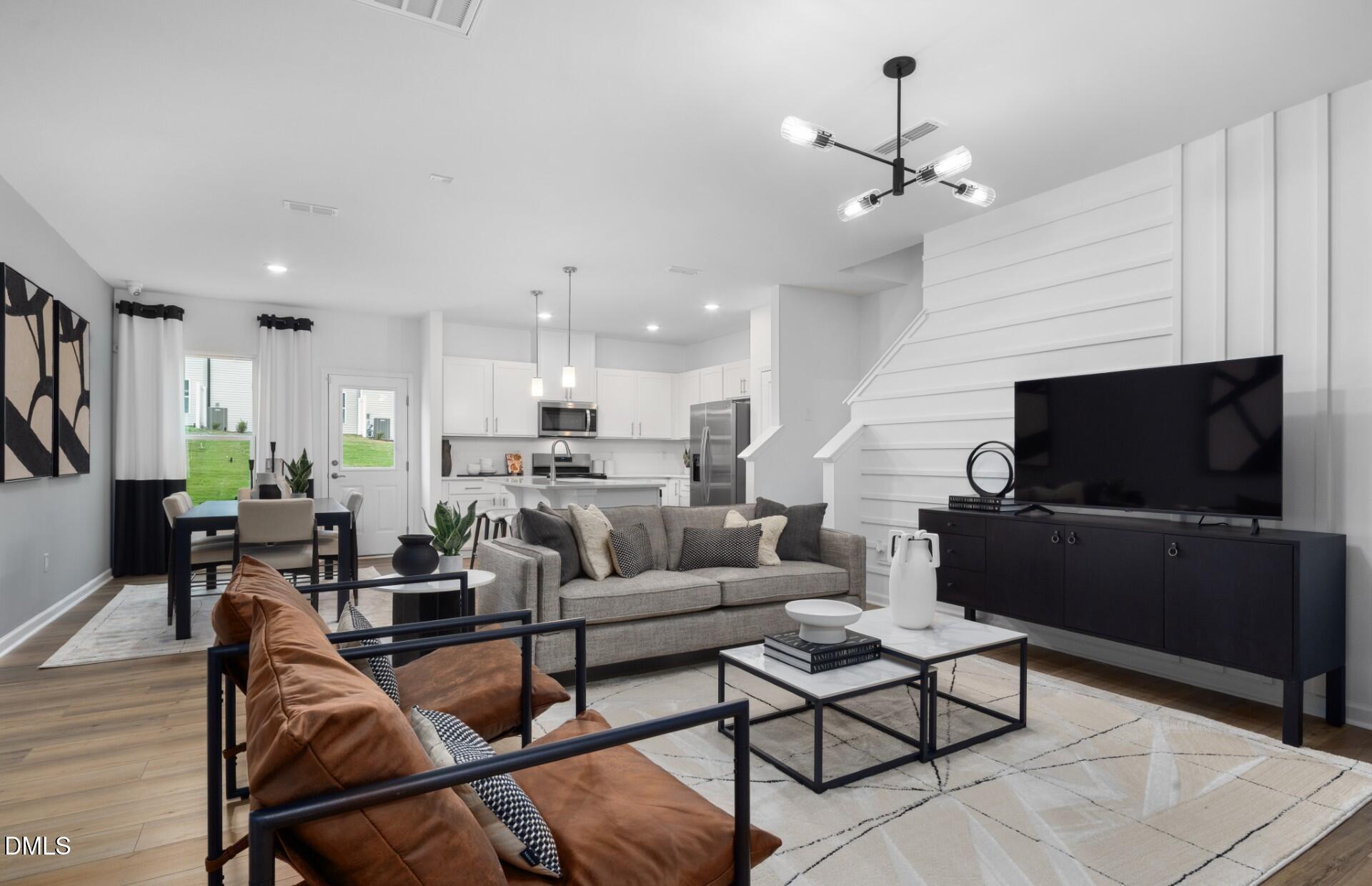 3015 Hammer Creek Road Durham, NC 27704 - Photo 7 of 18 a living room with furniture kitchen view and a flat screen tv