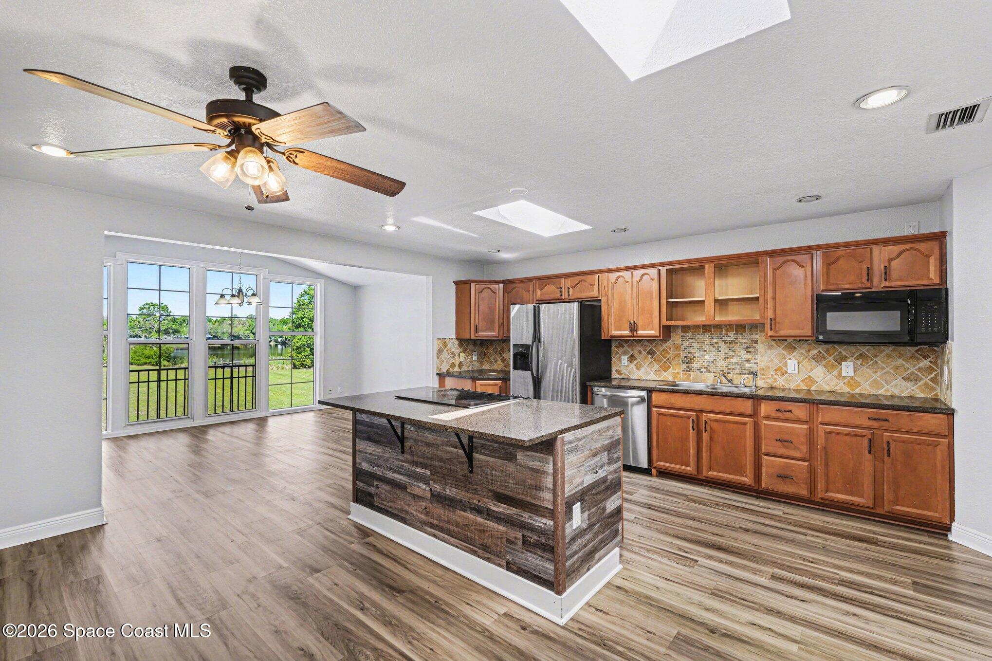 4950 Blounts Ridge Road Mims, FL 32754 - Photo 23 of 40 a kitchen with stainless steel appliances granite countertop a stove and a wooden floors