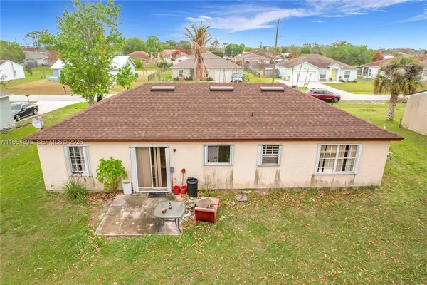 a view of a house with backyard and sitting area
