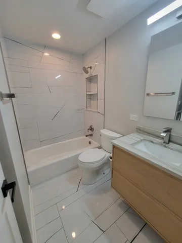 a bathroom with a sink a toilet a mirror and bathtub