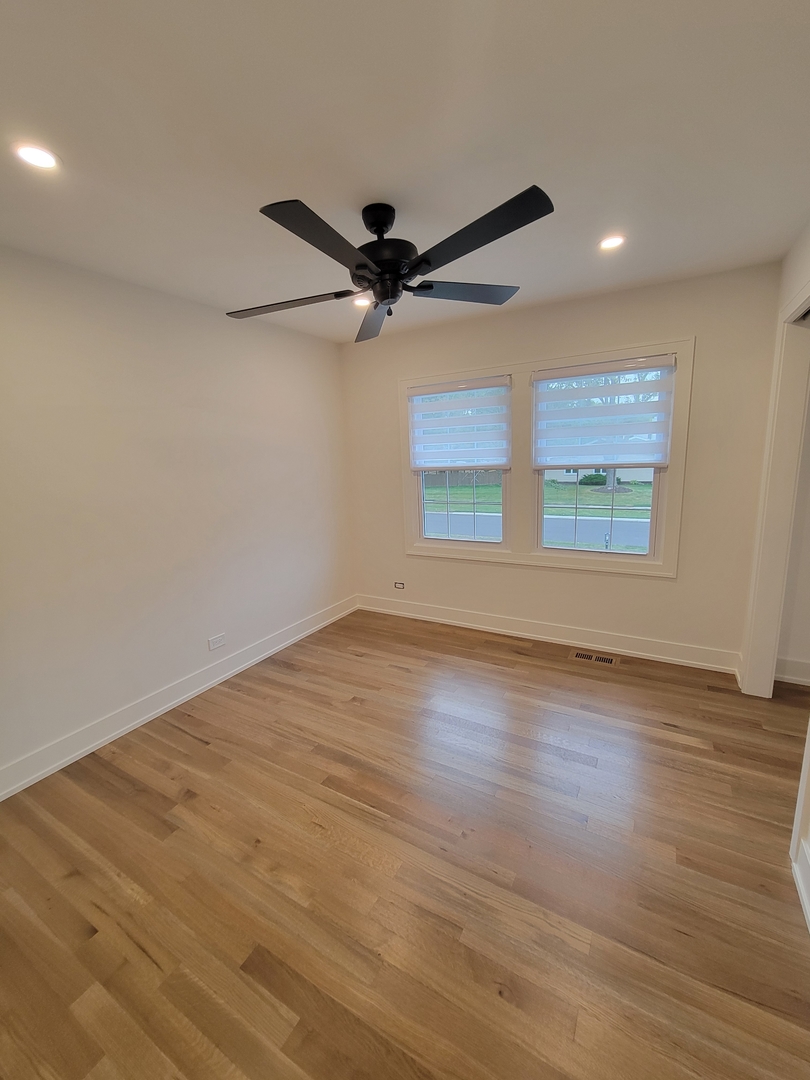 2S245 Mayfield Lane Glen Ellyn, IL 60137 - Photo 19 of 26 an empty room with wooden floor fan and windows