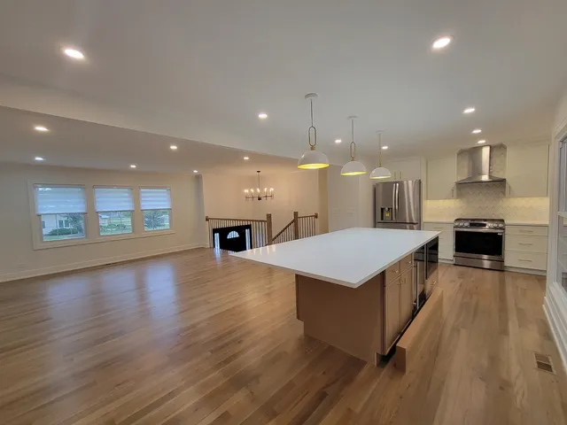 an open kitchen with kitchen island a sink dishwasher stove with wooden floors