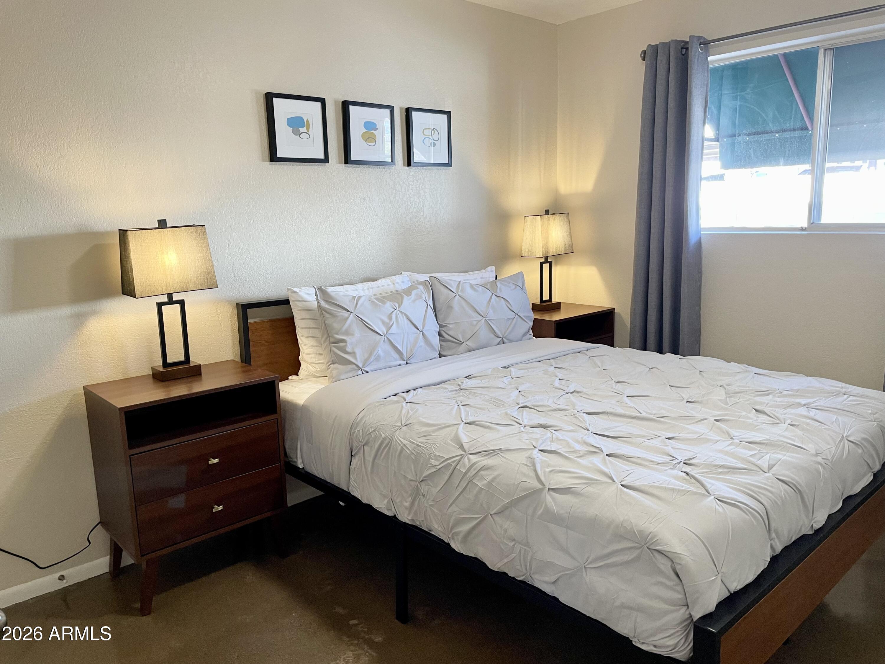6819 North 12th Street, Unit 9 Phoenix, AZ 85014 - Photo 12 of 21 a bedroom with a bed and a lamp
