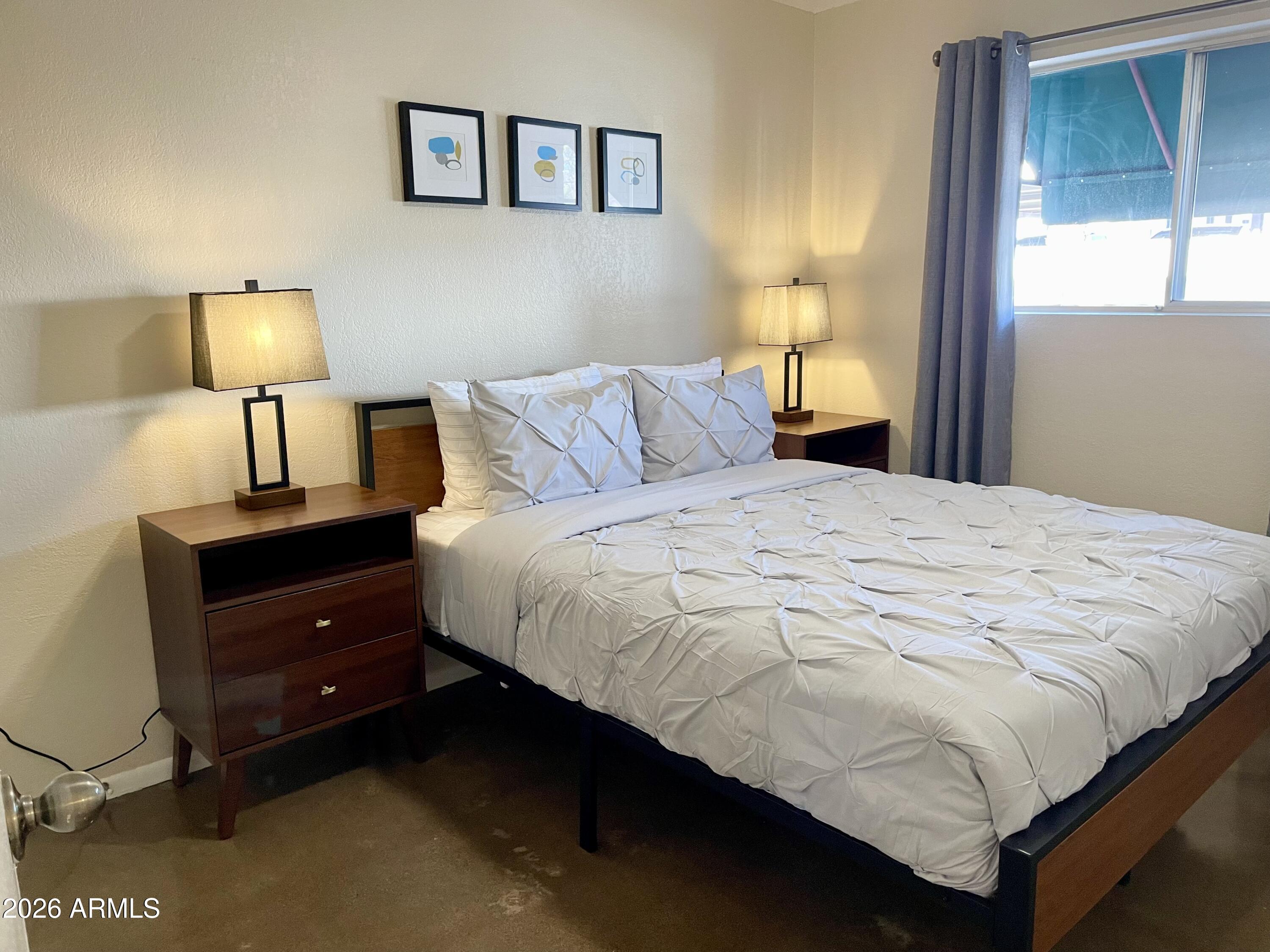 6819 North 12th Street, Unit 9 Phoenix, AZ 85014 - Photo 13 of 21 a bedroom with a bed and a night stand