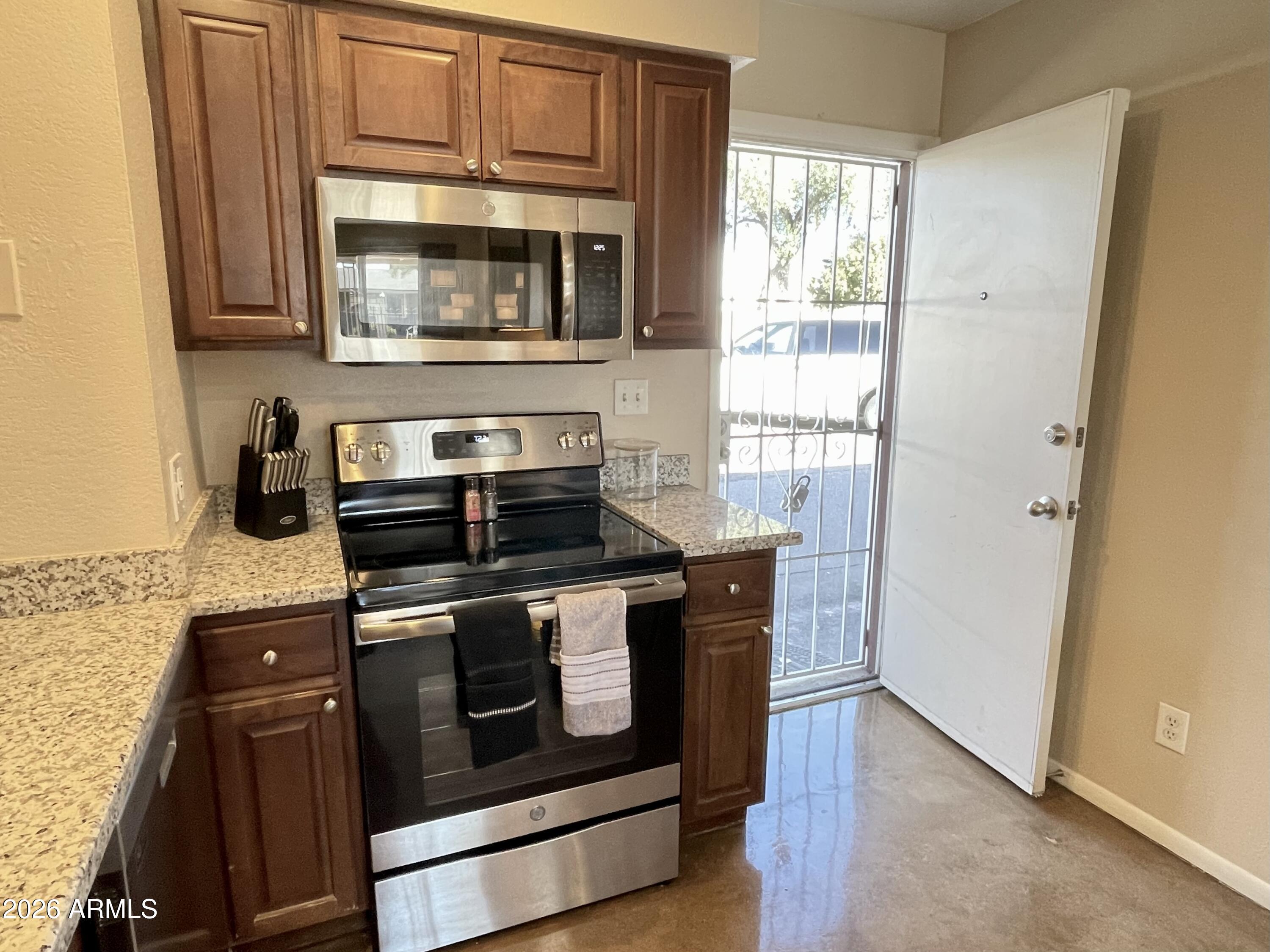 6819 North 12th Street, Unit 9 Phoenix, AZ 85014 - Photo 5 of 21 a kitchen with stainless steel appliances granite countertop a stove and a microwave