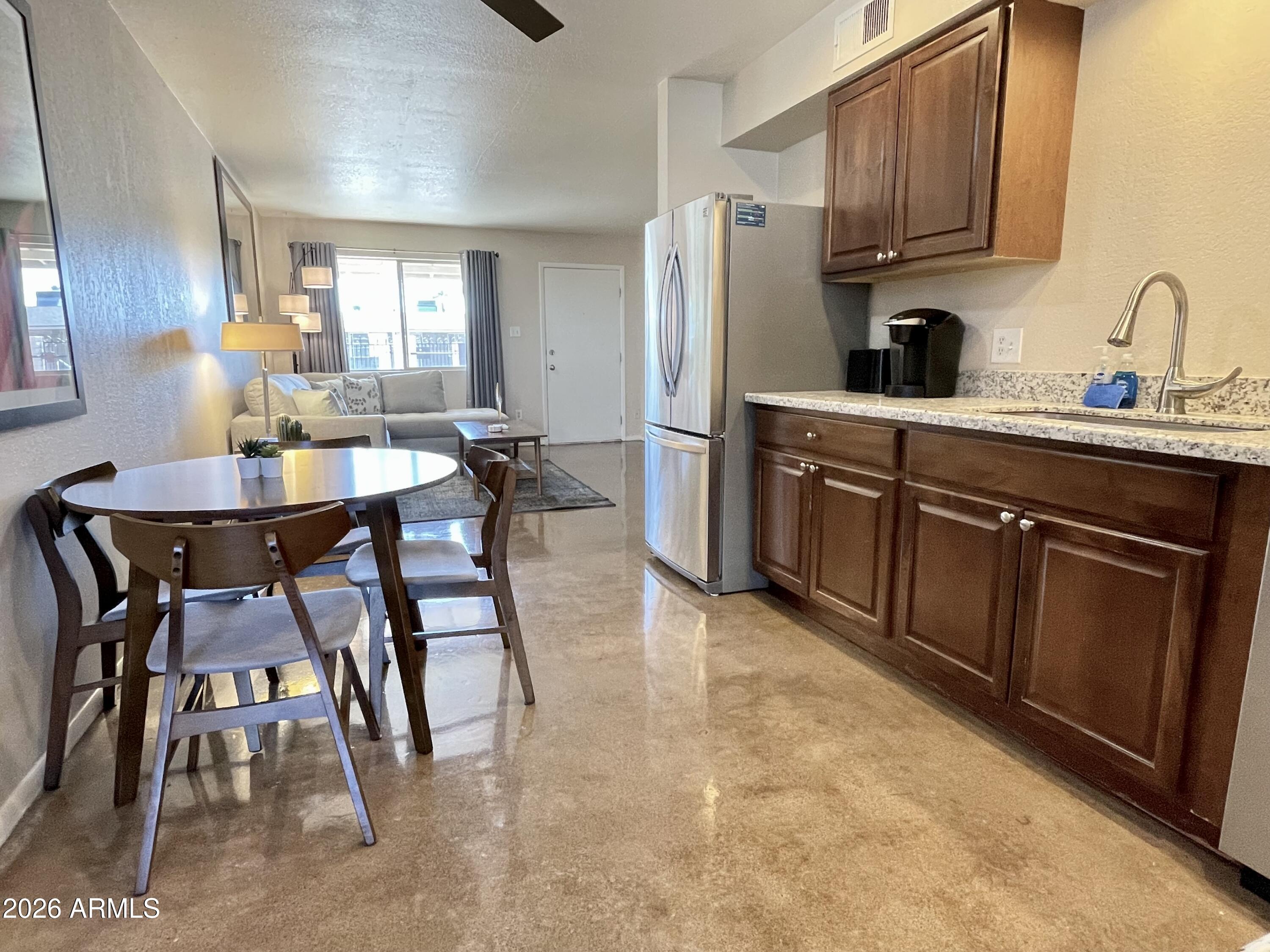 6819 North 12th Street, Unit 9 Phoenix, AZ 85014 - Photo 6 of 21 a kitchen with stainless steel appliances granite countertop a table chairs sink and cabinets