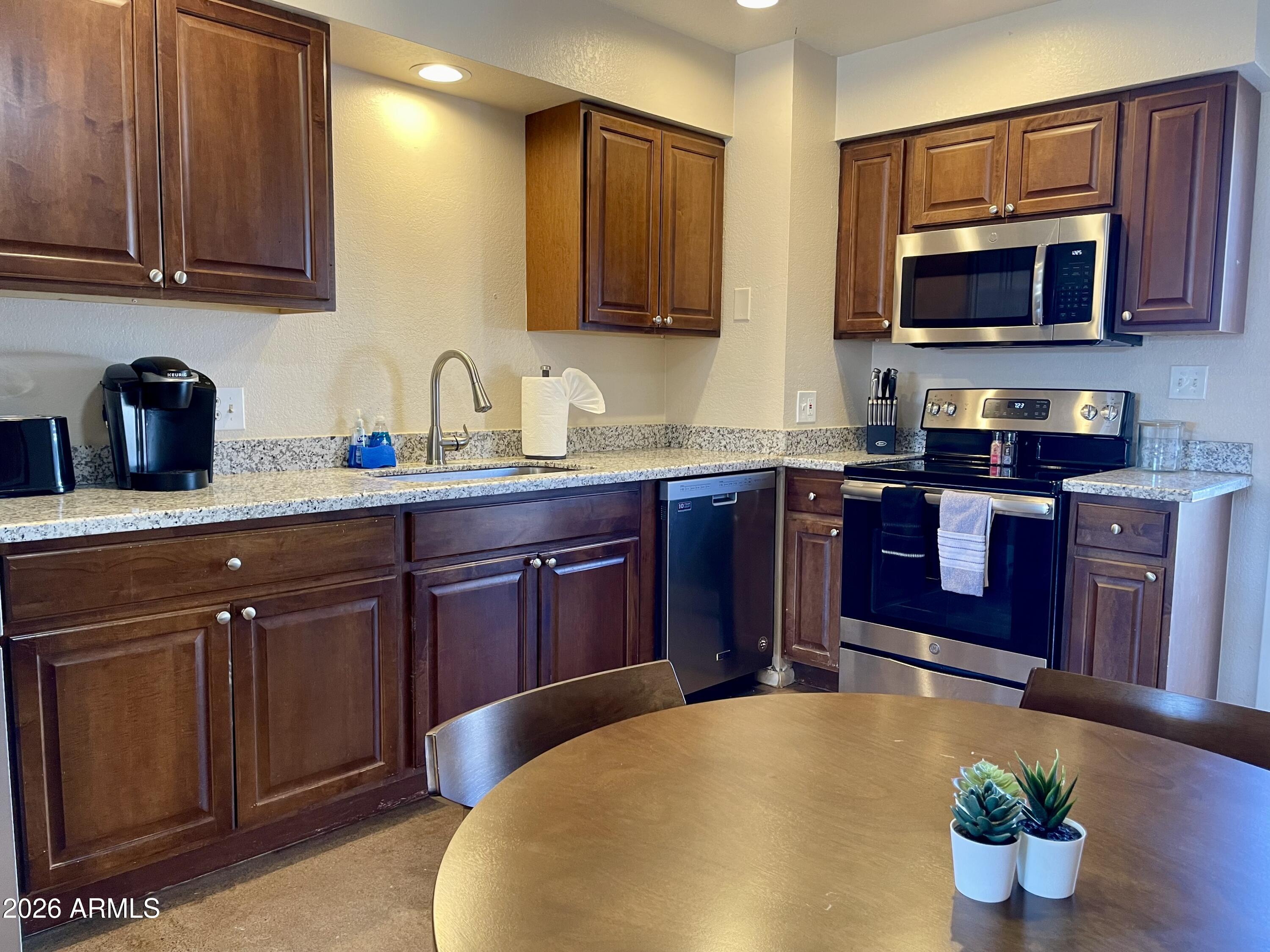 6819 North 12th Street, Unit 9 Phoenix, AZ 85014 - Photo 7 of 21 a kitchen with stainless steel appliances a stove a sink dishwasher and cabinets