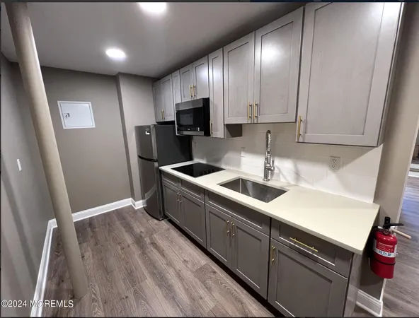 a kitchen that has a sink stainless steel appliances a counter space and cabinets