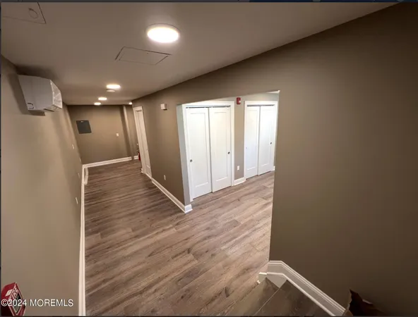a view of hallway with a window and wooden floor