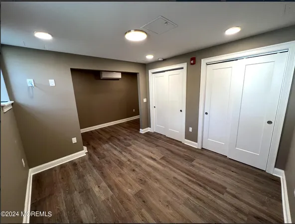an empty room with wooden floor and entrance