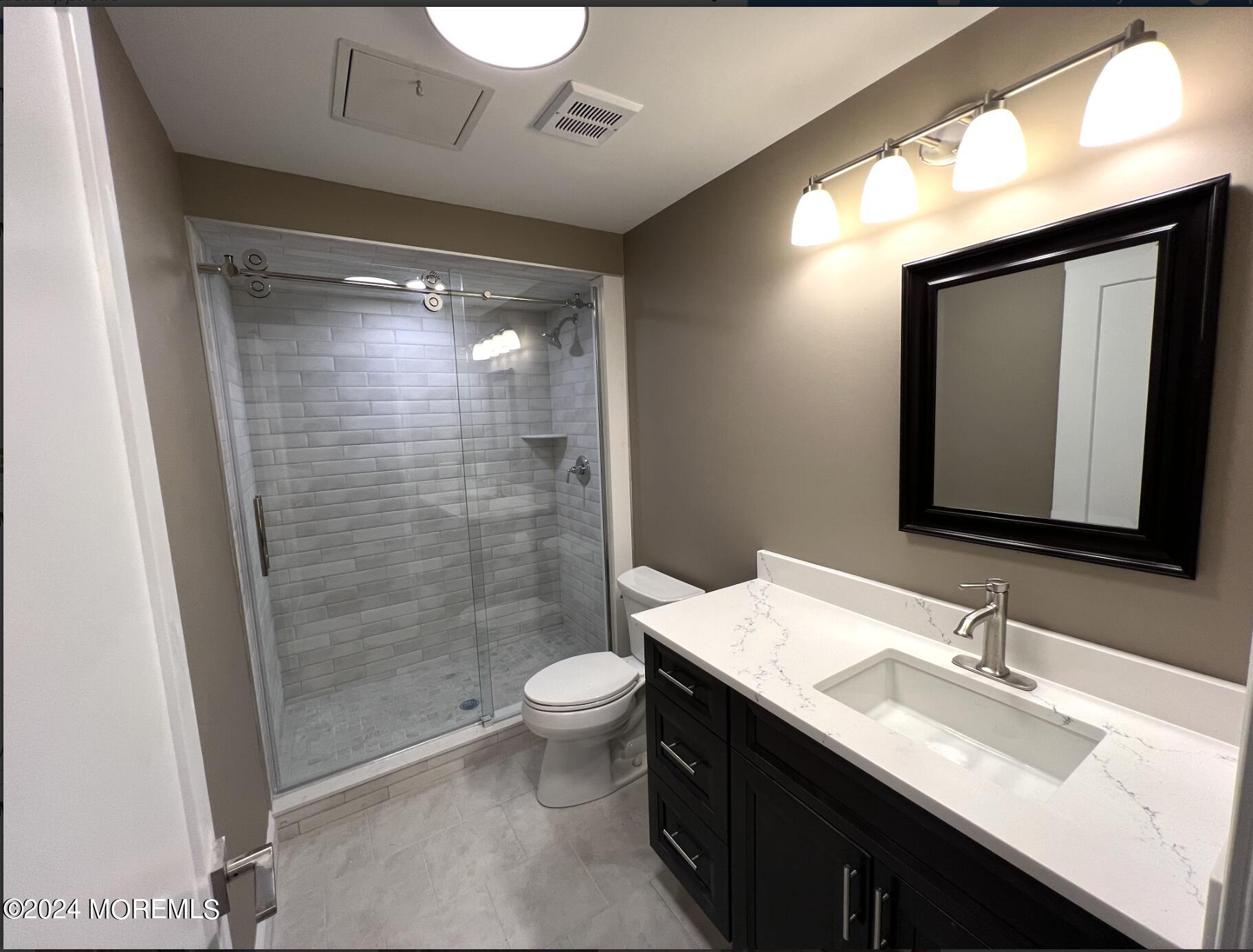 182-192 Broad Street, Unit 3 Red Bank, NJ 07701 - Photo 5 of 8 a bathroom with a sink a toilet a mirror and shower