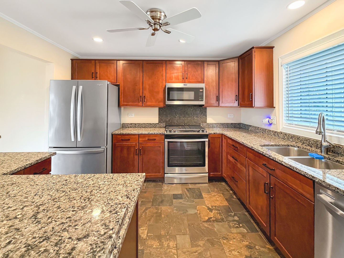 104 McClellan Street Bartlett, IL 60103 - Photo 5 of 21 a kitchen with stainless steel appliances granite countertop a refrigerator a sink a stove with wooden cabinets
