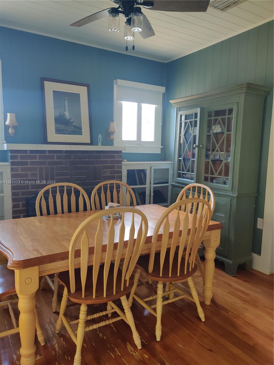 16475 Southwest 248th Street, Unit 16475 Homestead, FL 33031 - Photo 2 of 8 a view of a dining room with furniture wooden floor and chandelier