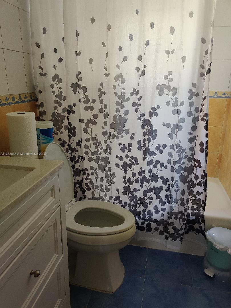 16475 Southwest 248th Street, Unit 16475 Homestead, FL 33031 - Photo 5 of 8 a bathroom with a toilet and a shower curtain