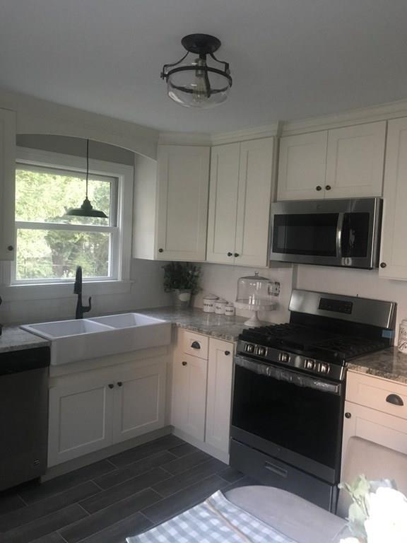 33 Surrey Road Springfield, MA 01118 - Photo 2 of 22 a kitchen with stainless steel appliances granite countertop a stove a sink and a microwave