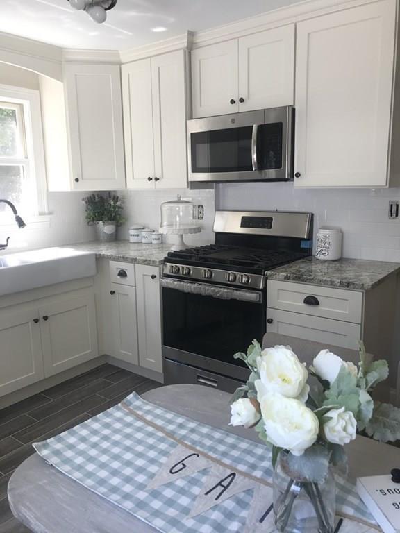 33 Surrey Road Springfield, MA 01118 - Photo 4 of 22 a kitchen with a stove a sink and a microwave