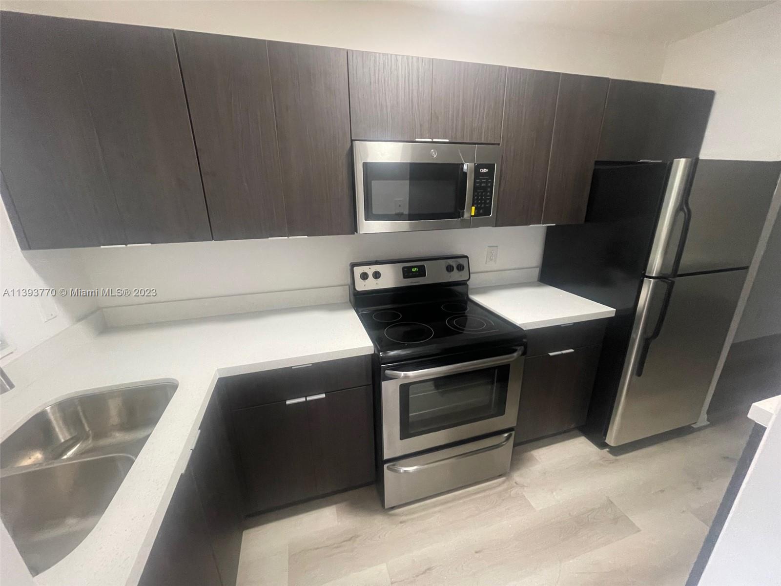 5300 Washington Street, Unit G324 Hollywood, FL 33021 - Photo 3 of 7 a kitchen with a sink and a microwave