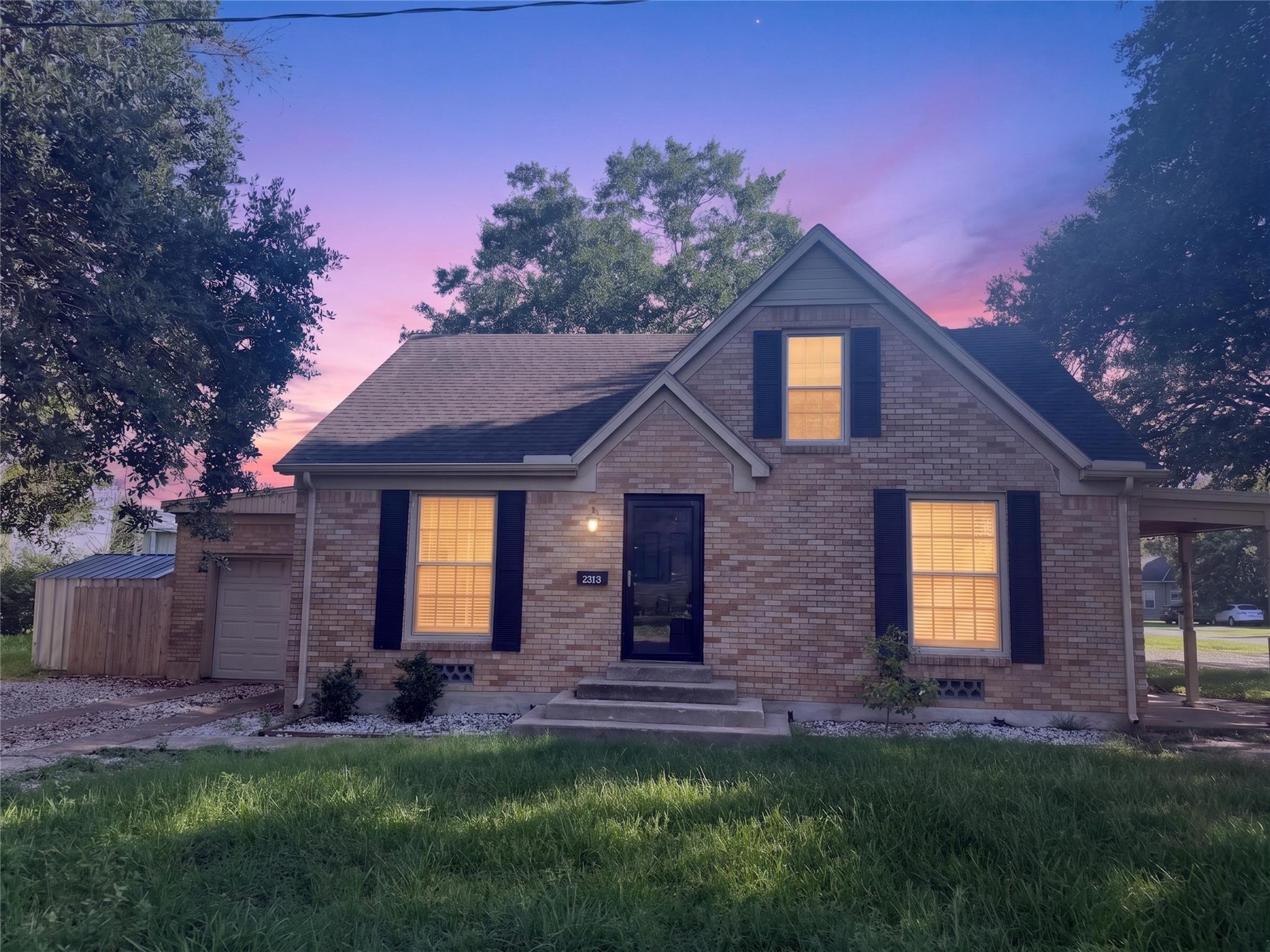 2313 Avenue L Rosenberg, TX 77471 - Photo 30 of 31 Twilight-enhanced front elevation with warm interior lighting creating a welcoming first impression.