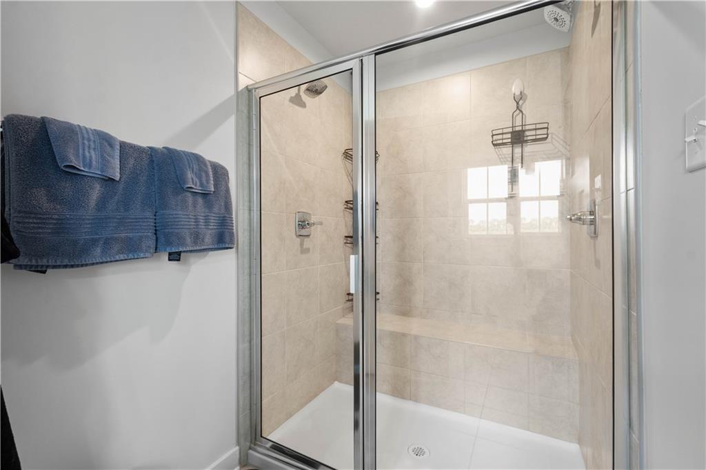254 Regency Drive Eighty Four, PA 15330 - Photo 22 of 44 Spacious primary bathroom featuring a tiled walk-in shower with a built-in bench seat and dual shower heads, creating a spa-like retreat.