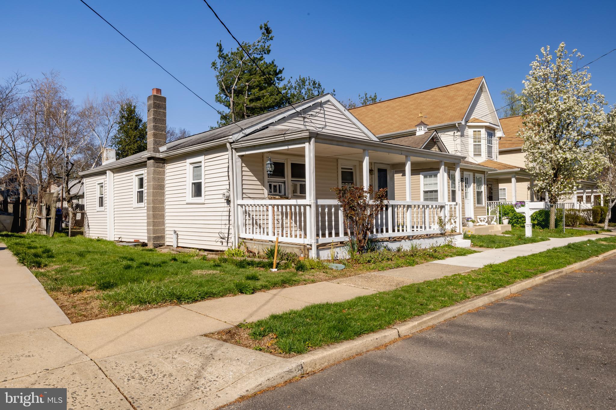 228 Rancocas Avenue Delanco, NJ 08075 - Photo 3 of 14 a view of a white house with a small yard and large trees