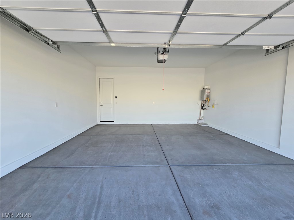 852 Weston Ridge Street Henderson, NV 89011 - Photo 25 of 28 A spacious, newly finished garage offers ample parking and storage, featuring a concrete floor and a clean, bright interior.