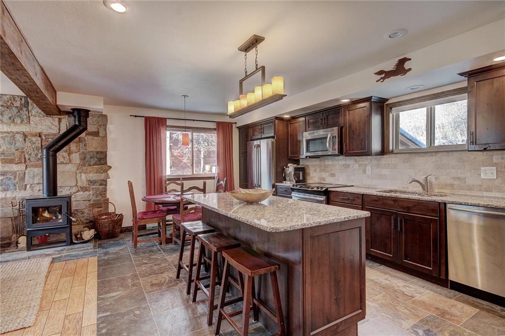 187 Rasor Drive Keystone, CO 80435 - Photo 11 of 24 a kitchen with stainless steel appliances granite countertop wooden cabinets a stove top oven a sink a dining table and chairs