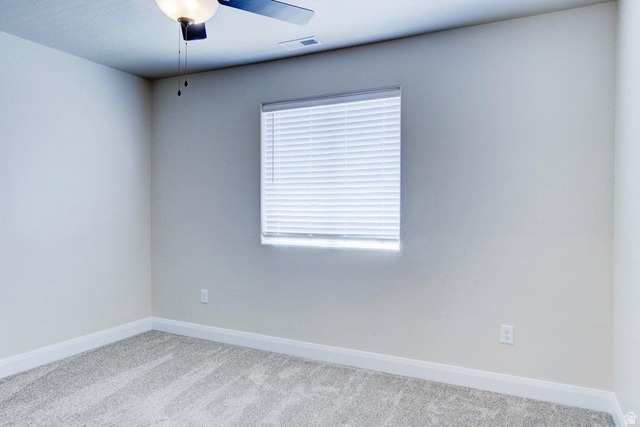 668 East Fiddlers Canyon Road, Unit 24 Cedar City, UT 84721 - Photo 10 of 21 Spare room with light colored carpet and a ceiling fan