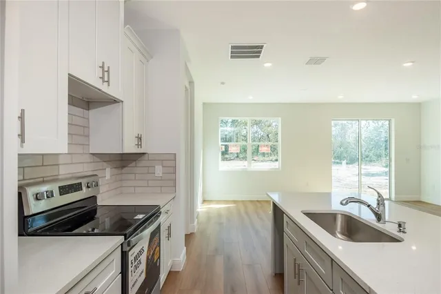 a kitchen with granite countertop a stove and a sink