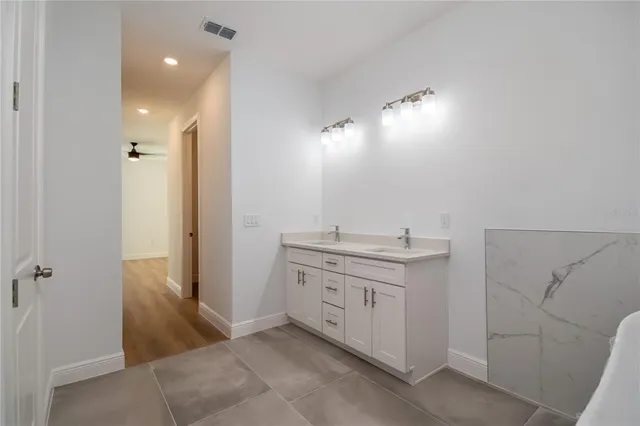 a bathroom with a double vanity sink a toilet and shower