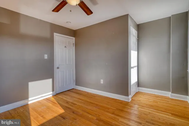 a view of empty room with wooden floor
