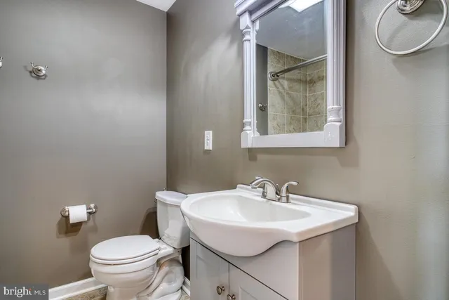 a bathroom with a sink toilet and a mirror