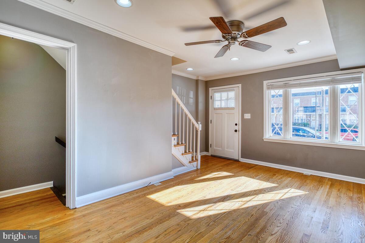 340 Gusryan Street Baltimore, MD 21224 - Photo 7 of 34 a view of an empty room with window and wooden floor