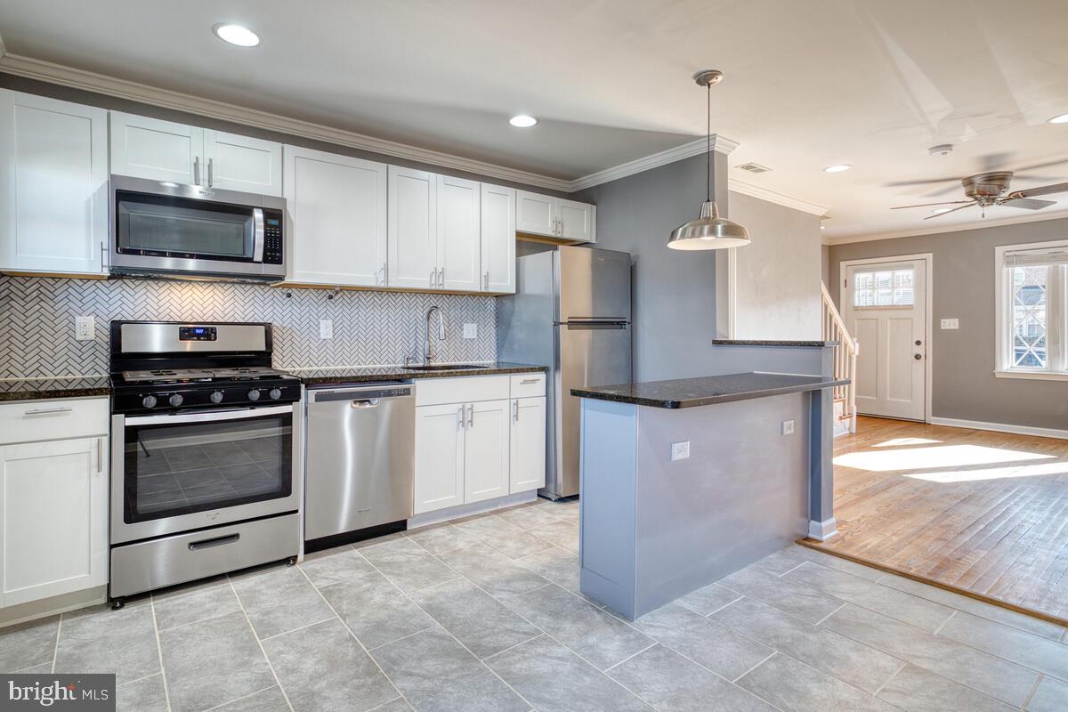 340 Gusryan Street Baltimore, MD 21224 - Photo 10 of 34 a kitchen with stainless steel appliances granite countertop a stove a sink and a microwave