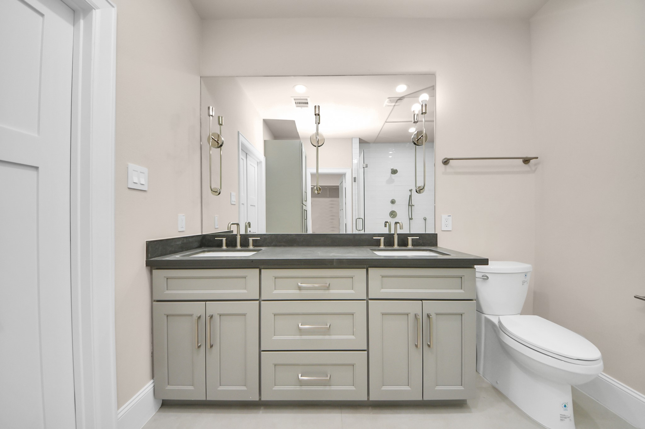6320 Milwee Street, Unit B Houston, TX 77092 - Photo 30 of 43 a bathroom with a granite countertop toilet a mirror and a sink