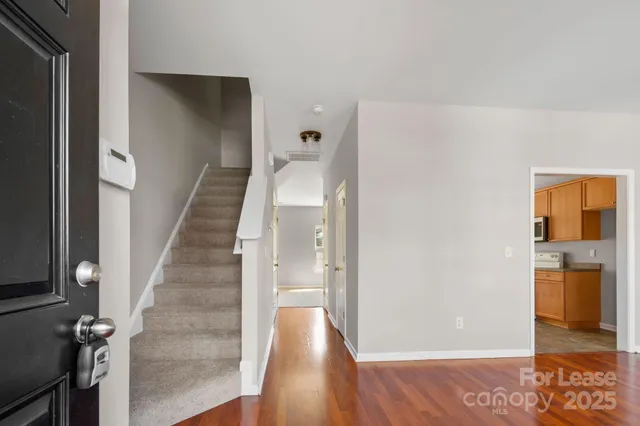 a view of a hallway with wooden floor and staircase