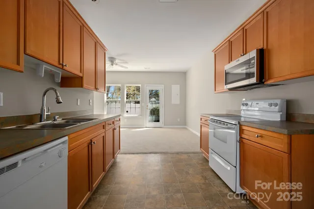 a kitchen with stainless steel appliances granite countertop a sink stove and cabinets