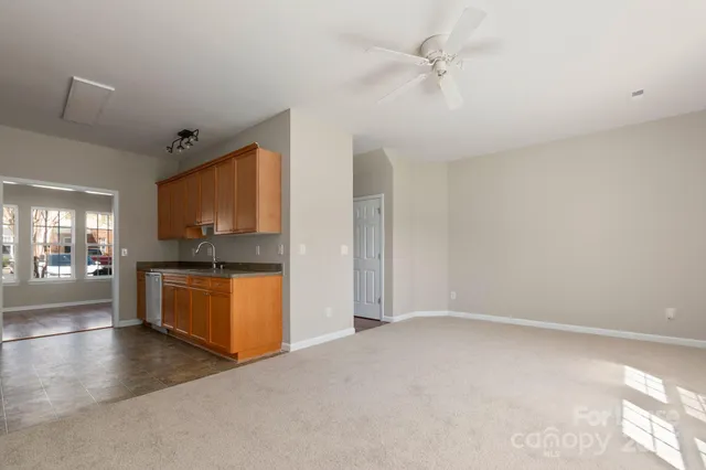a view of a kitchen with a sink dishwasher a refrigerator with wooden floor