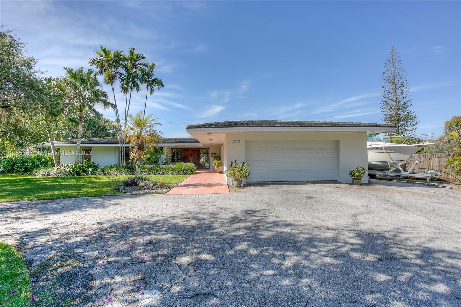 9670 Southwest 96th Court Miami, FL 33176 - Photo 2 of 21 a view of a house with a yard and a garage