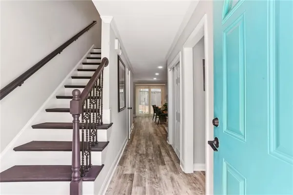 a view of a hallway with wooden floor and staircase