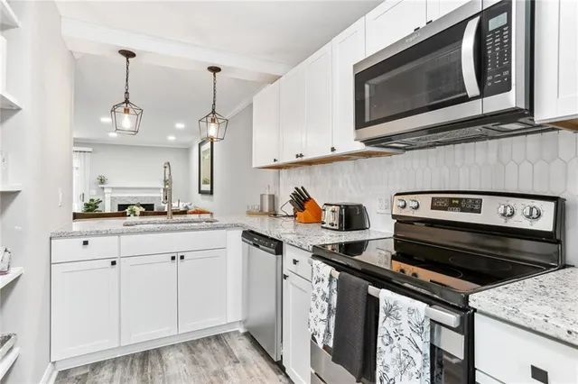 a kitchen with stainless steel appliances granite countertop a sink and a stove