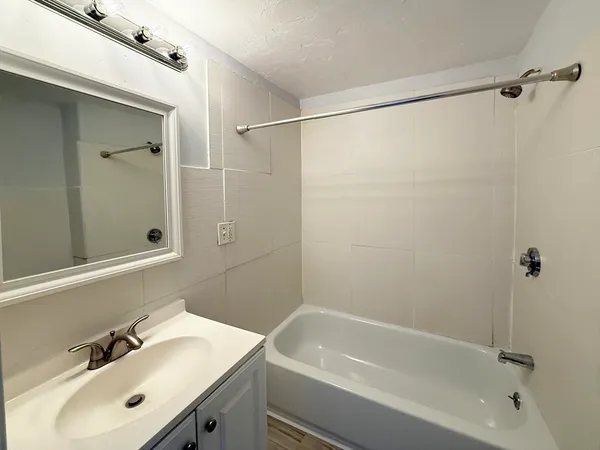 a bathroom with a sink mirror and shower