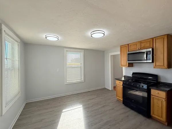 a kitchen with granite countertop a stove a sink and a microwave