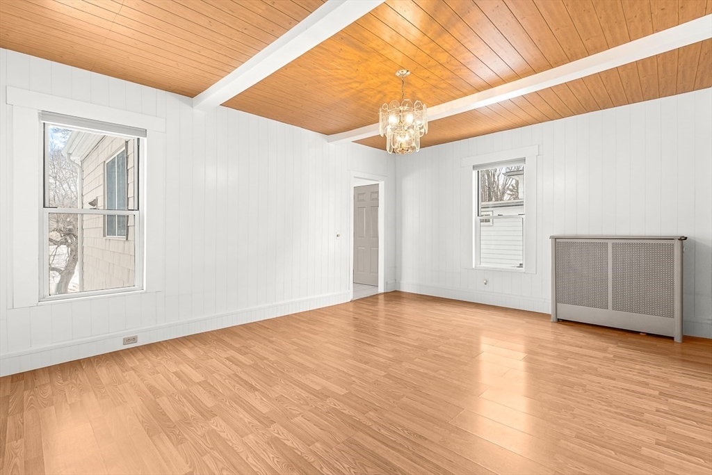 20 Pond Street Stoneham, MA 02180 - Photo 14 of 35 an empty room with wooden floor chandelier and windows