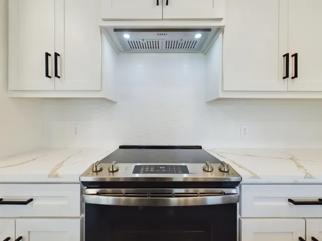 a stove top oven sitting inside of a kitchen