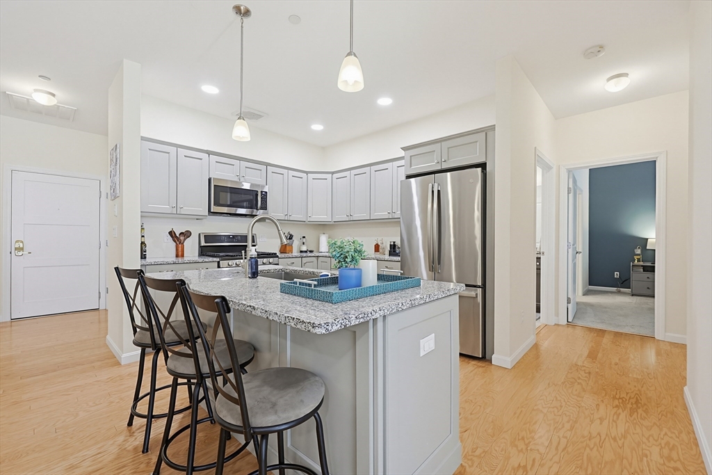 200 Revere Street, Unit 4209 Canton, MA 02021 - Photo 8 of 35 a kitchen that has a table chairs refrigerator and microwave