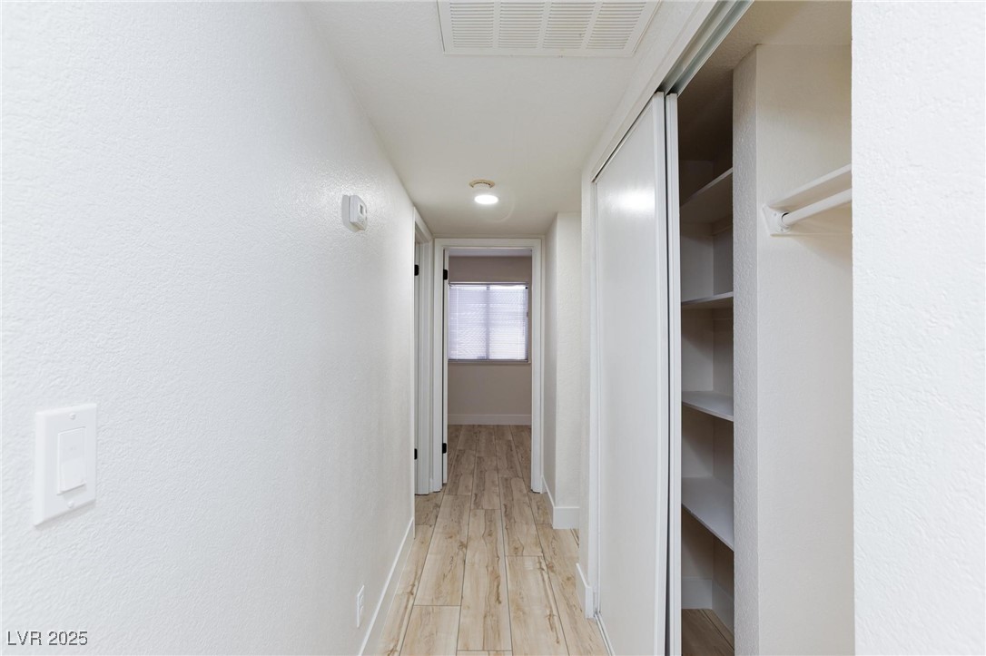 5905 Smoke Ranch Road, Unit A Las Vegas, NV 89108 - Photo 16 of 31 Hall featuring light wood-style flooring and a textured wall