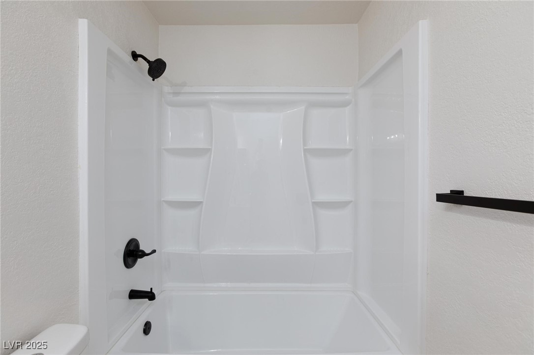 5905 Smoke Ranch Road, Unit A Las Vegas, NV 89108 - Photo 18 of 31 Full bathroom featuring a textured wall and shower / bath combination