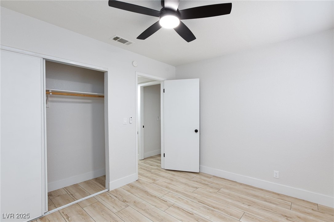 5905 Smoke Ranch Road, Unit A Las Vegas, NV 89108 - Photo 21 of 31 Unfurnished bedroom with light wood finished floors, ceiling fan, and a closet